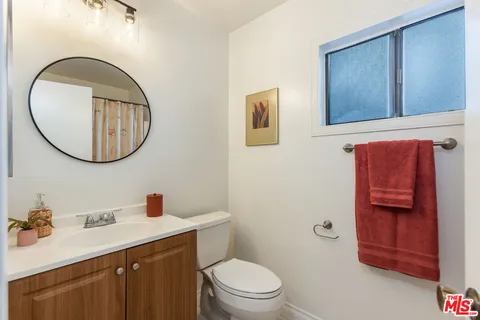 a bathroom with a toilet a sink and mirror