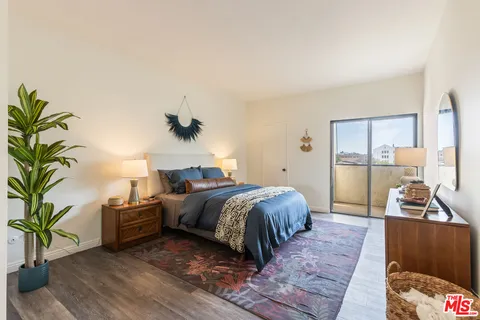 a bedroom with a large bed and a potted plant