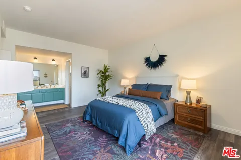 a spacious bedroom with a bed and a potted plant