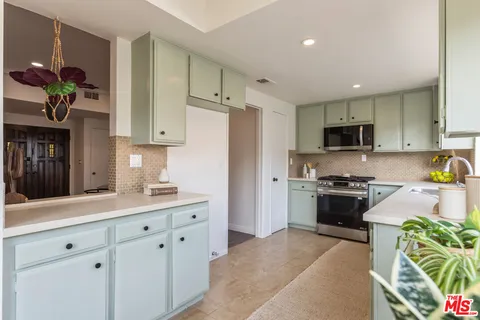 a kitchen with stainless steel appliances granite countertop a refrigerator sink and stove