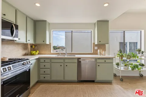 a kitchen with stainless steel appliances granite countertop a stove a sink and a microwave
