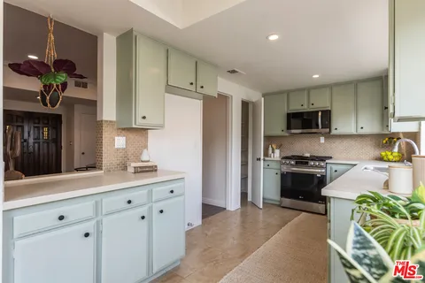 a kitchen with stainless steel appliances granite countertop a refrigerator sink and stove