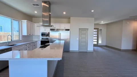 a kitchen with stainless steel appliances kitchen island wooden floors cabinets and wooden floor
