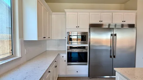 a kitchen with kitchen island granite countertop a sink and a stove top oven