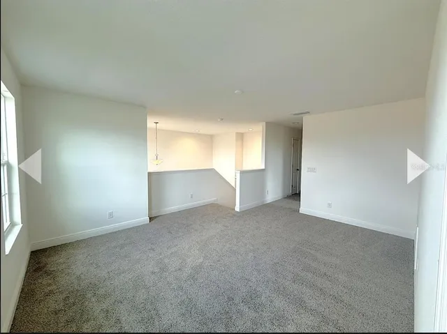 an empty room with windows and cabinet