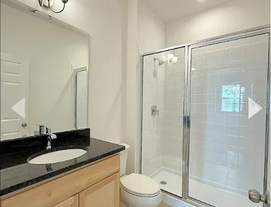 a bathroom with a granite countertop sink toilet mirror and shower