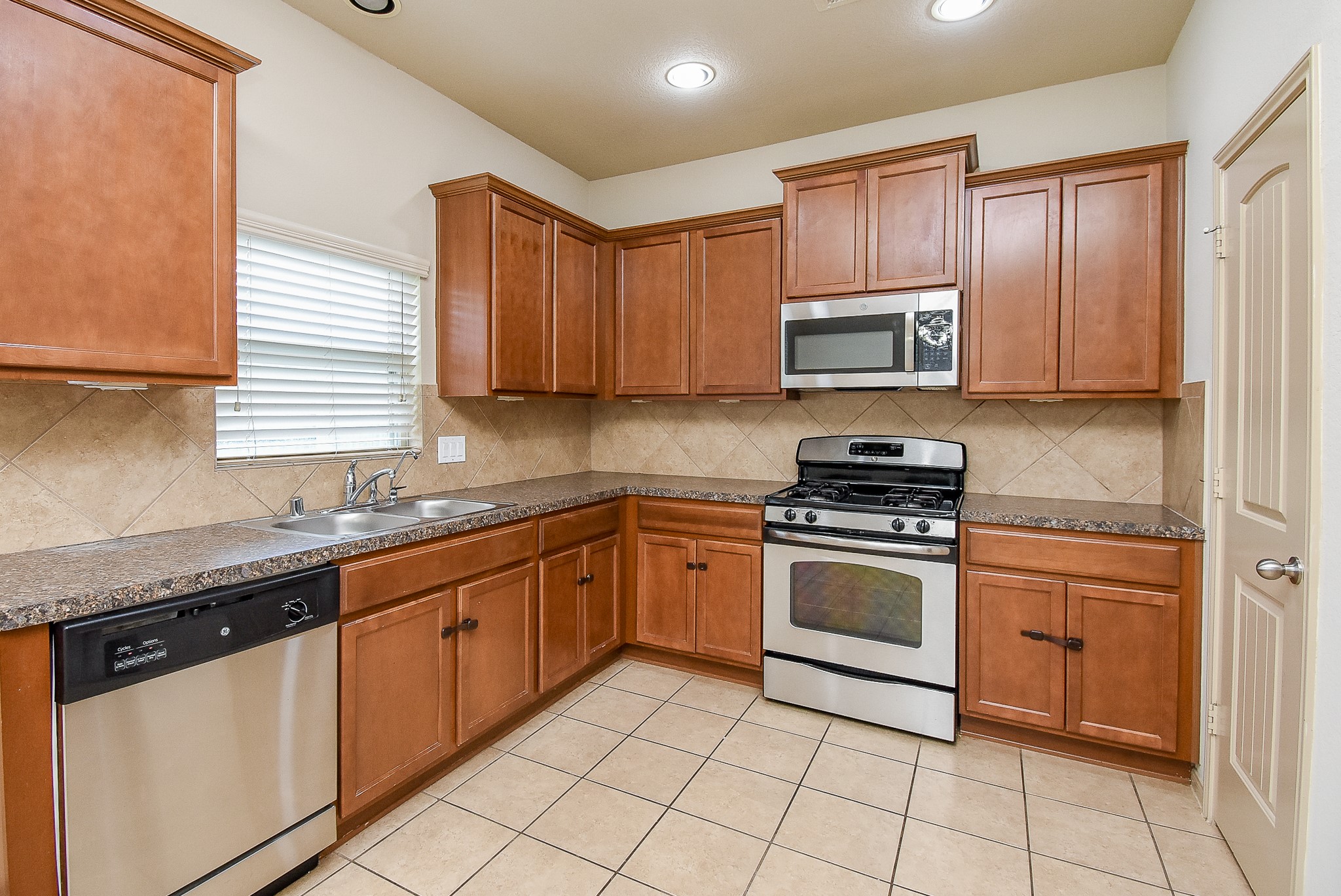 2106 Harmon Crest Court Spring, TX 77373 - Photo 12 of 32 a kitchen with granite countertop cabinets stainless steel appliances and a sink