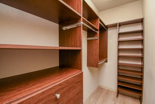a view of walk in closet with empty racks