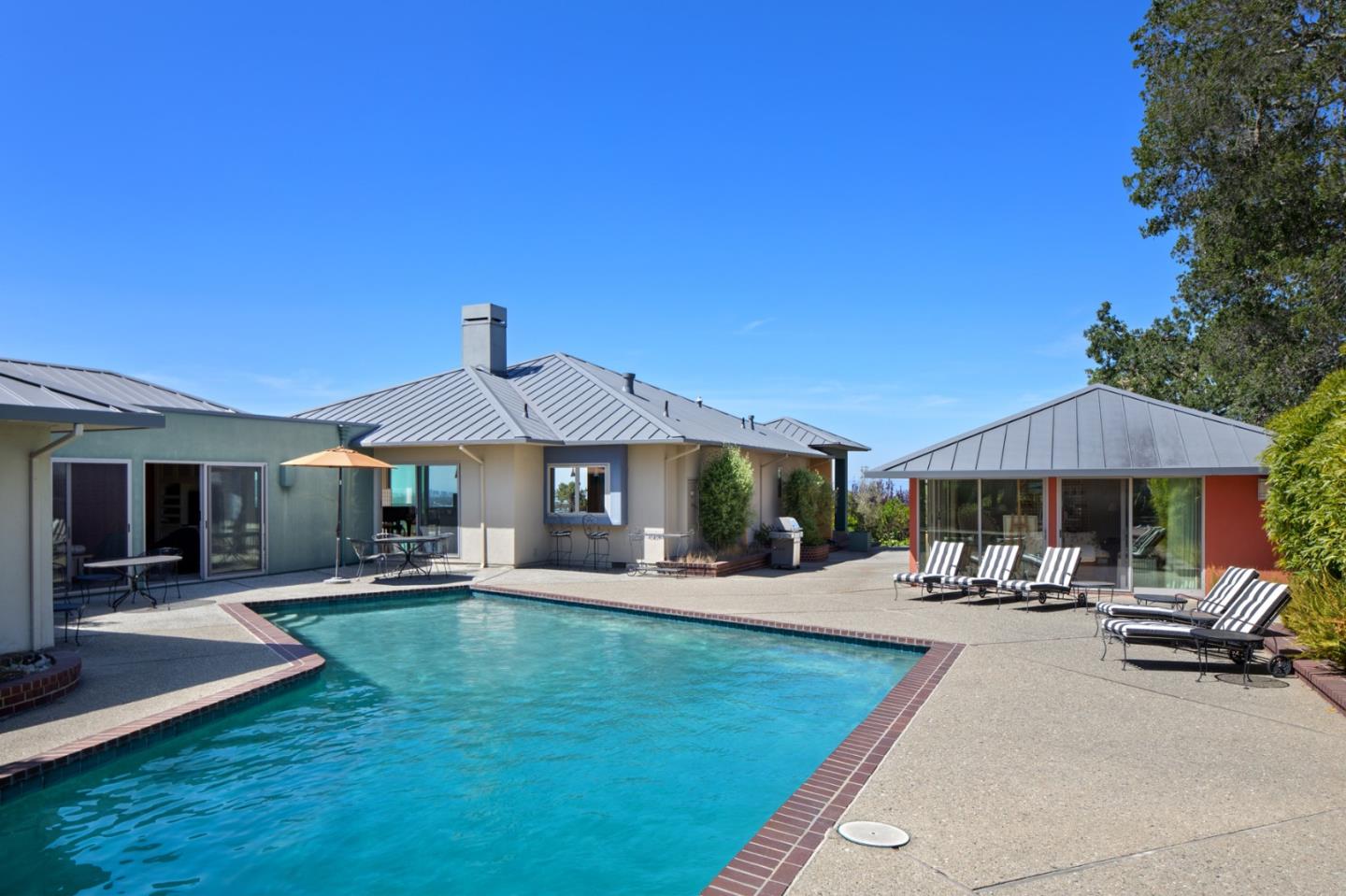 45 Melanie Lane Atherton, CA 94027 - Photo 3 of 4 a patio with a table and chairs under an umbrella