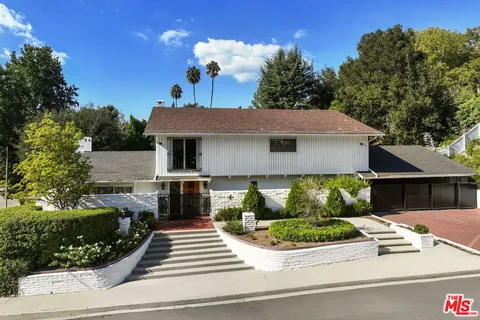 a front view of a house with a garden