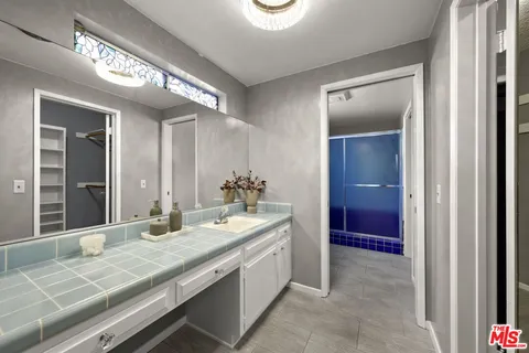 a bathroom with a granite countertop sink and a mirror