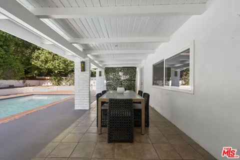 a front view of a house with sitting area and garden