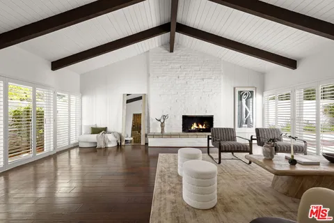 a living room with fireplace furniture and a large window