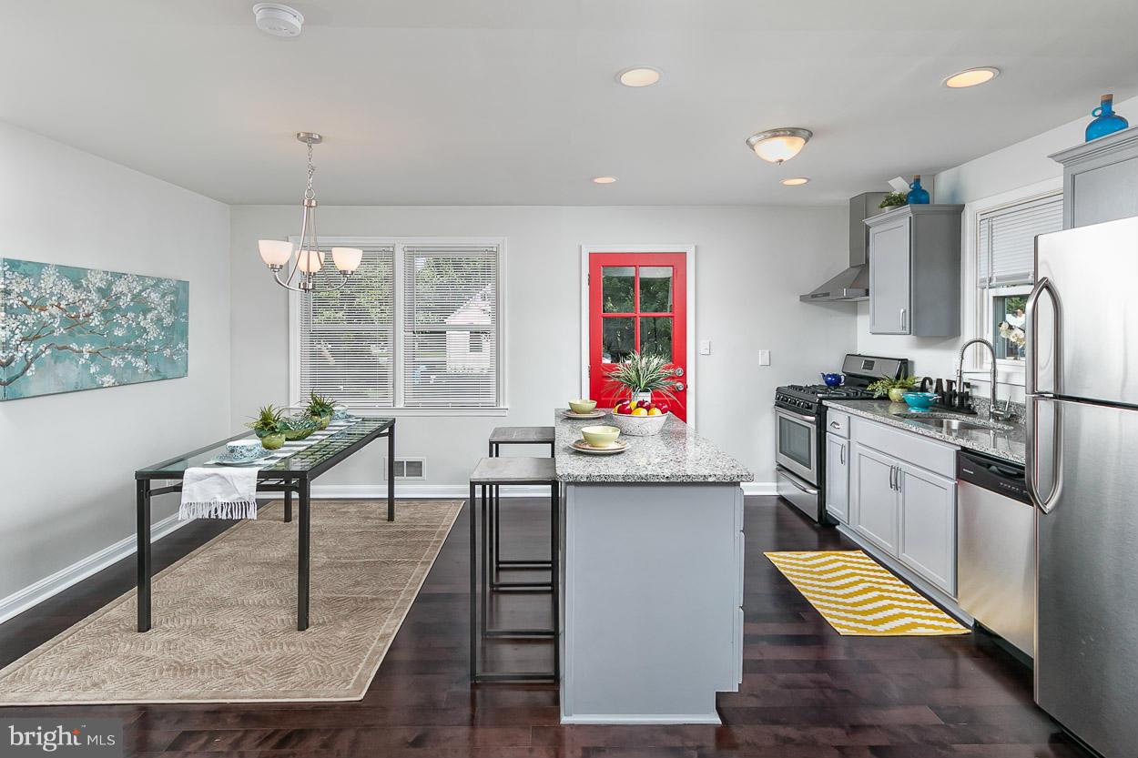 1816 Forrest Road Baltimore, MD 21234 - Photo 9 of 19 a kitchen with stainless steel appliances granite countertop a stove top oven a sink dishwasher and a dining table with wooden floor