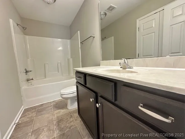 a bathroom with a granite countertop sink a toilet a mirror and bathtub