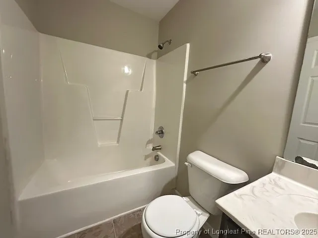a white toilet and tub sitting next to a bathroom sink