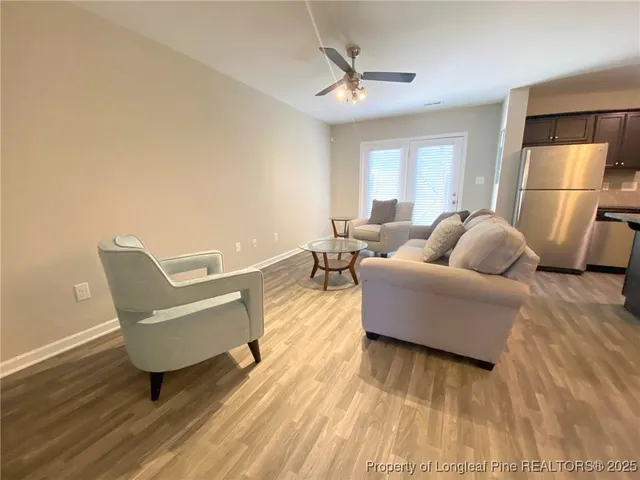 a living room with furniture and a wooden floor