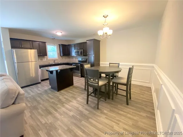 a view of a dining room with furniture and a chandelier