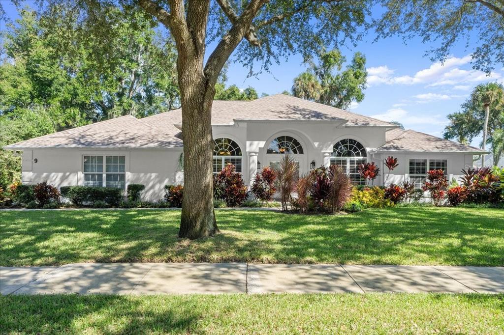 9 Emerald Oaks Lane Ormond Beach, FL 32174 - Photo 1 of 1 a view of a white house in front of a big yard with large trees