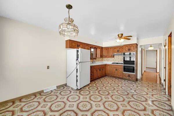 a kitchen that has a lot of cabinets and wooden floor