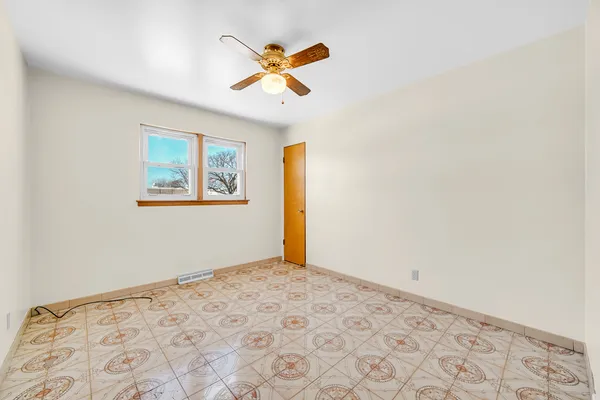 a view of a big room with wooden floor and a ceiling fan