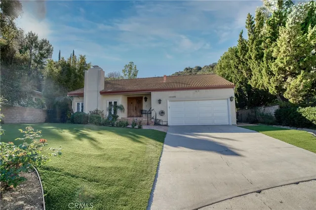 a view of a house with table and chairs under an umbrella