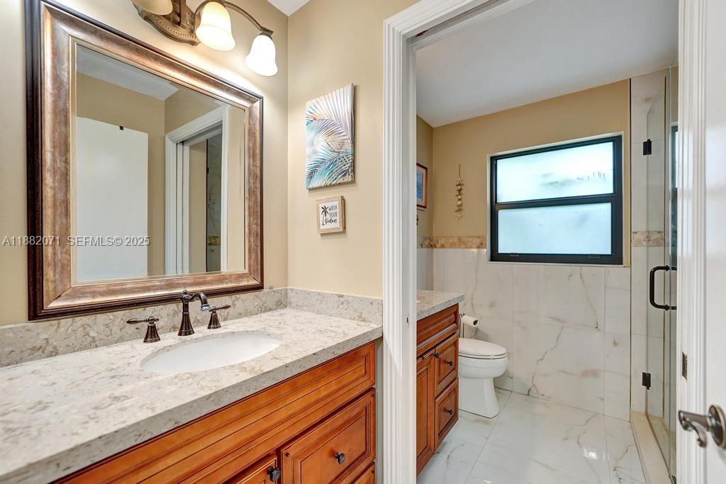 3187 Beechberry Circle Davie, FL 33328 - Photo 15 of 20 a bathroom with a granite countertop sink mirror vanity and toilet