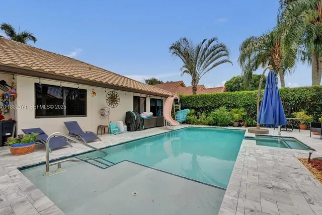 a view of a house with backyard and sitting area
