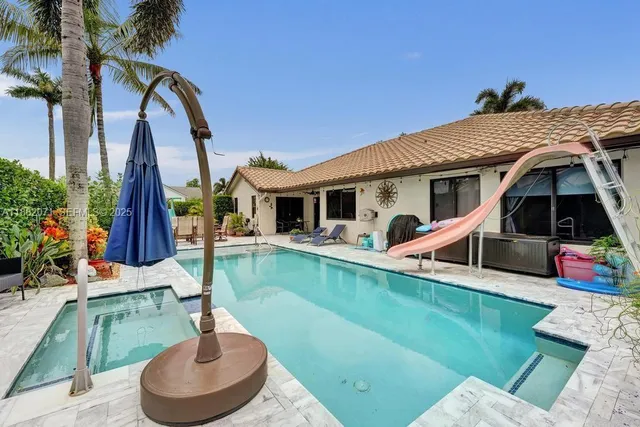a view of a house with swimming pool and a yard