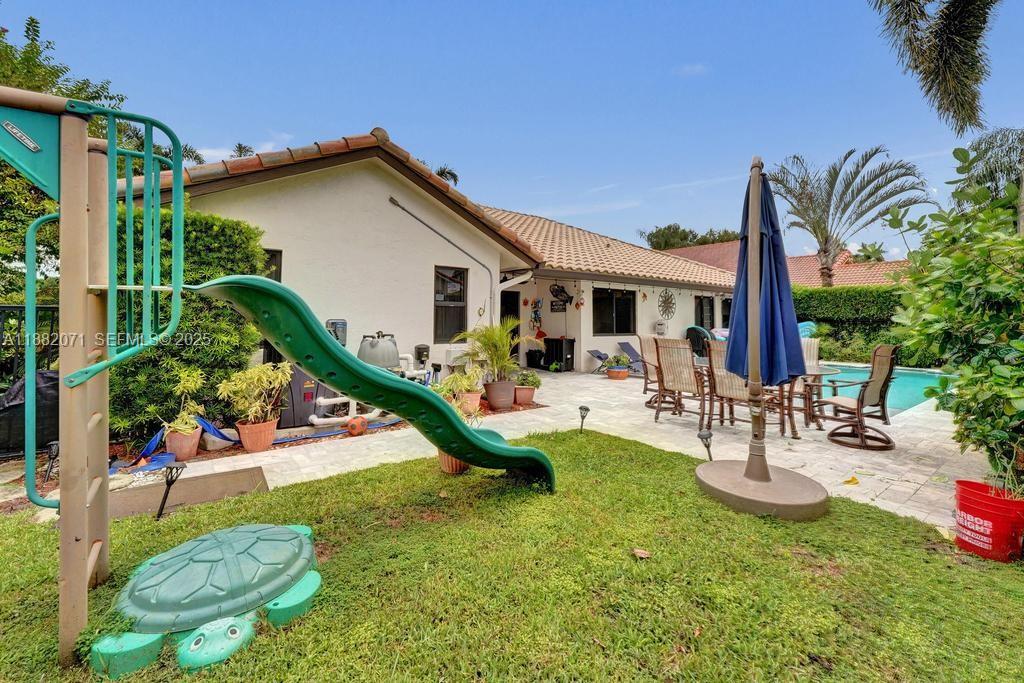 3187 Beechberry Circle Davie, FL 33328 - Photo 6 of 20 a view of a house with swimming pool and a yard