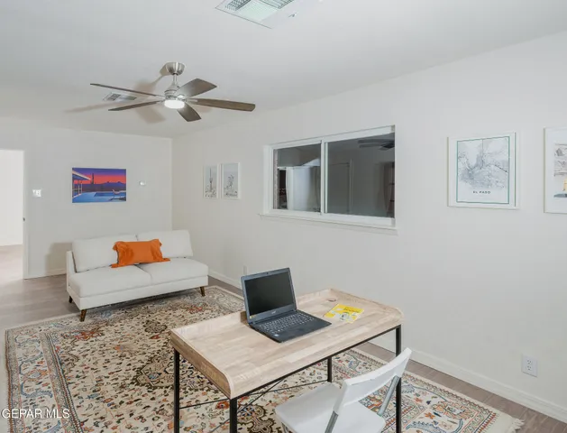 a dining room with wooden floor a chandelier fan a wooden table and chairs