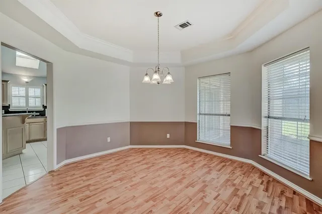 a view of a livingroom with a chandelier fan and windows