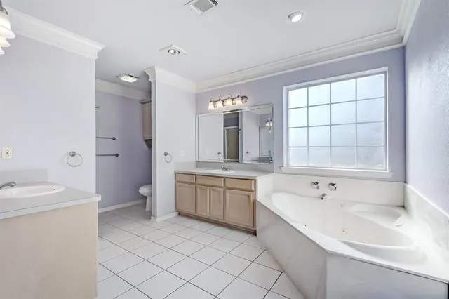 a spacious bathroom with a double vanity sink toilet mirror and bathtub