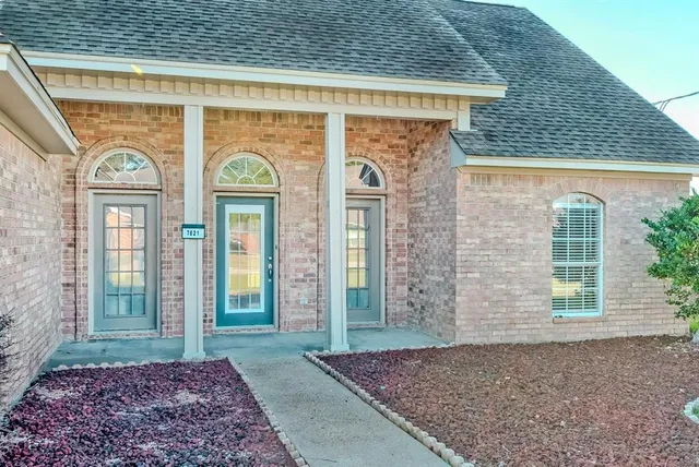 a view of a brick house with large windows