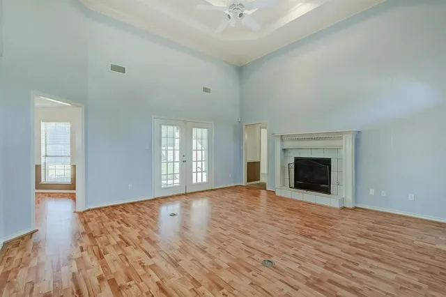 wooden floor fireplace and windows in an empty room