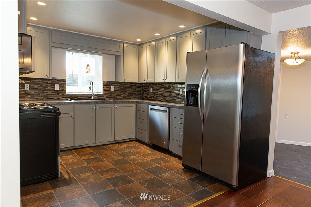 23605 5th Avenue West Bothell, WA 98021 - Photo 7 of 20 a kitchen with stainless steel appliances granite countertop a refrigerator a sink a stove top oven and cabinets