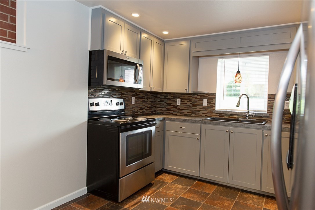 23605 5th Avenue West Bothell, WA 98021 - Photo 8 of 20 a kitchen with stainless steel appliances granite countertop a stove a sink and a microwave