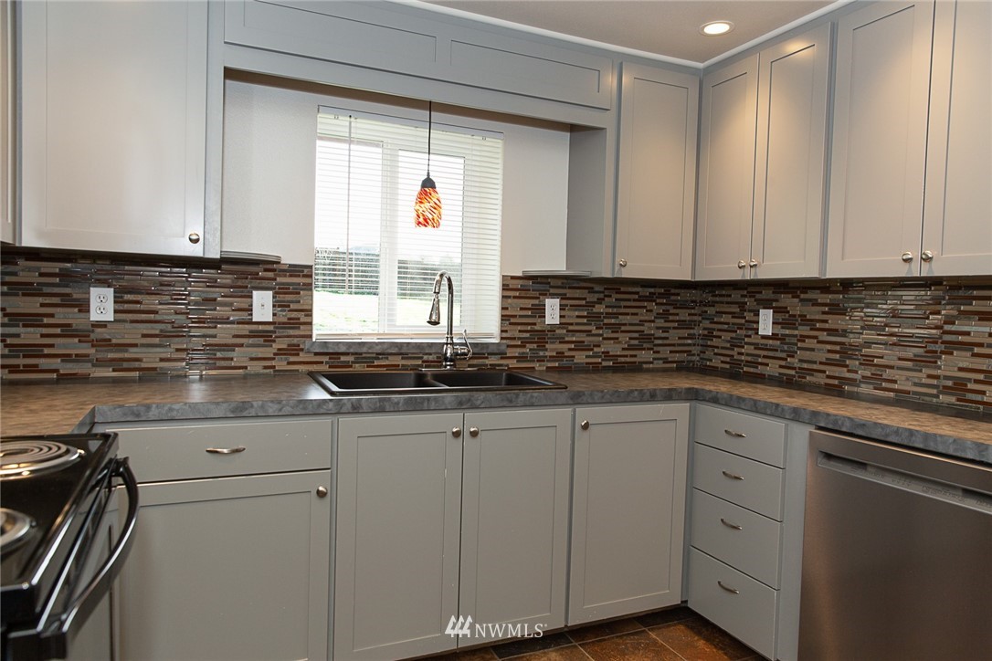 23605 5th Avenue West Bothell, WA 98021 - Photo 9 of 20 a kitchen with granite countertop white cabinets and sink