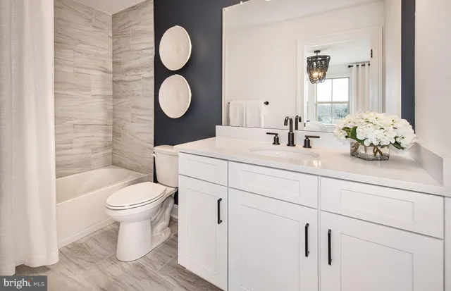 a bathroom with a granite countertop toilet sink mirror and vanity