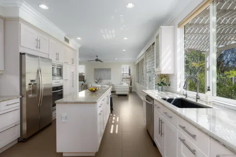 a kitchen that has a lot of cabinets a sink and appliances in it