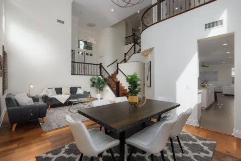 a view of a dining room and livingroom with furniture wooden floor a rug and a chandelier