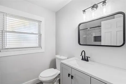 a bathroom with a toilet a sink and mirror