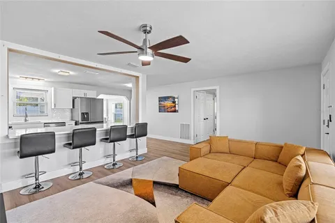 a living room with furniture and a view of kitchen