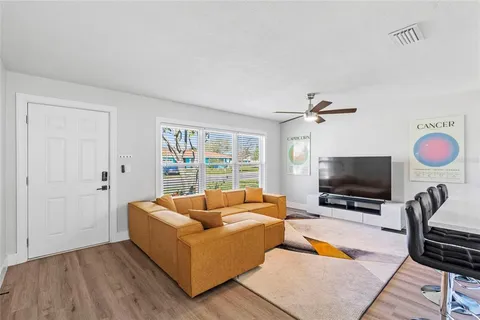 a living room with furniture a flat screen tv and a window