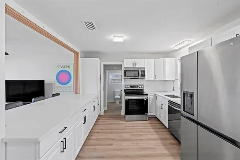 a kitchen with stainless steel appliances a stove microwave and a refrigerator