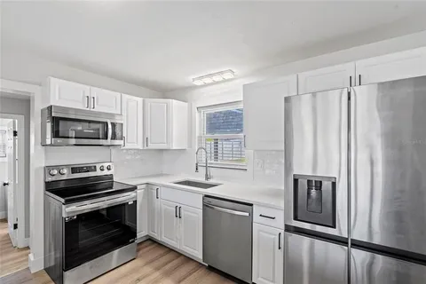 a kitchen with stainless steel appliances a refrigerator stove and microwave