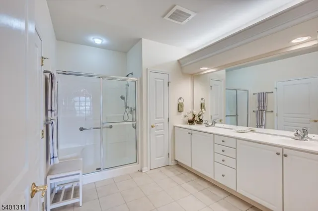 a spacious bathroom with a shower sink and mirror