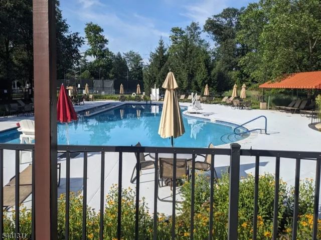 a view of a swimming pool with a patio and fire pit