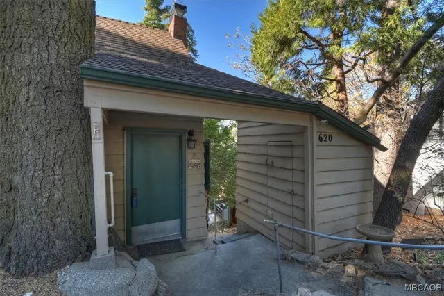 a view of a house with a yard and large tree