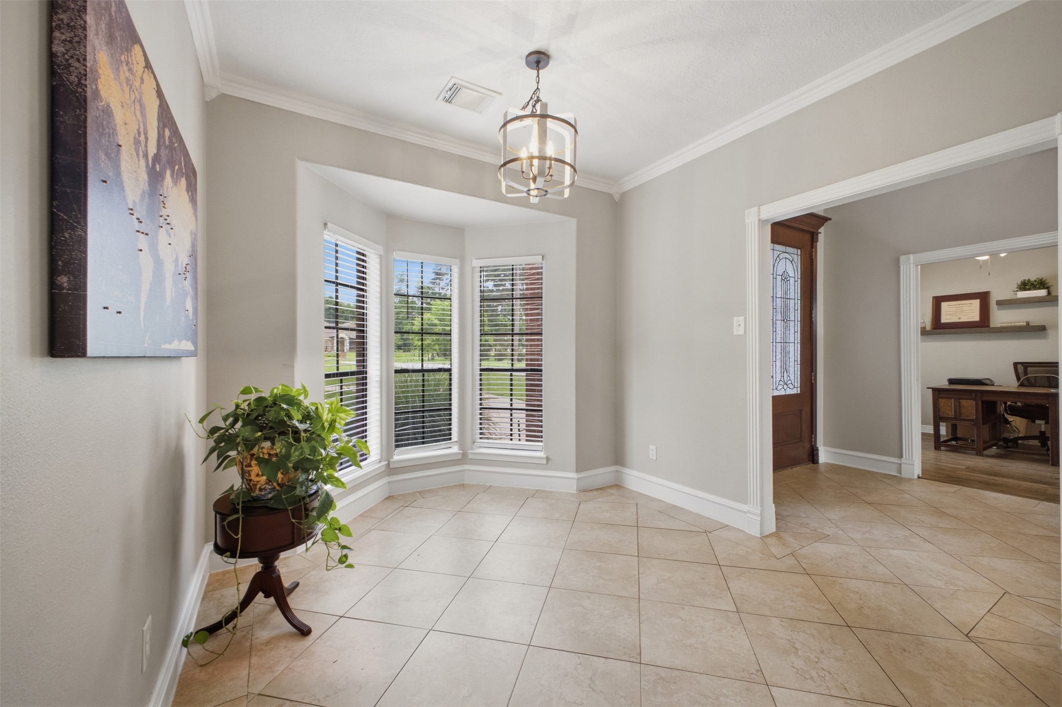 12710 Aries Loop Willis, TX 77318 - Photo 5 of 40 Entryway featuring a bay window with blinds, tile flooring, and a decorative chandelier